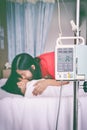 Asian boy lying on sickbed with infusion pump intravenous IV drip. Vintage style. Royalty Free Stock Photo