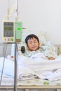 Asian boy lying on sickbed with infusion pump intravenous IV dri