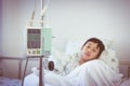 Asian boy lying on sickbed with infusion pump intravenous IV drip. Retro style. Royalty Free Stock Photo