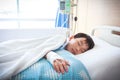 Asian boy lying on sickbed with saline intravenous (IV). Health