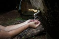 Asian boy open metal blue water faucet empty land.