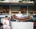 Asian boy play the ranat ek Thai musical xylophone instrument in the percussion