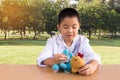 Asian boy playing as a doctor care bear doll Royalty Free Stock Photo