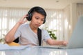 Asian boy playing guitar and watching online course on laptop while practicing for learning music or musical instrument online at Royalty Free Stock Photo