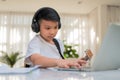 Asian boy playing guitar and watching online course on laptop while practicing for learning music or musical instrument online at Royalty Free Stock Photo