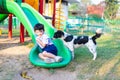 Asian boy playing with his dog in playground under sun light Royalty Free Stock Photo