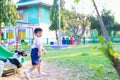 Asian boy playing with his dog in playground under sun light Royalty Free Stock Photo