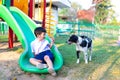 Asian boy playing with his dog in playground under sun light Royalty Free Stock Photo