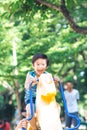 An Asian boy is playing a rocking horse in an outdoor playground Royalty Free Stock Photo