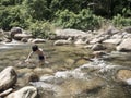 An Asian boy playing in the stream. Royalty Free Stock Photo