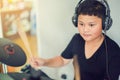 Asian boy put black tshirt and headphone learning and play electronic drum