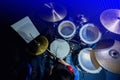 Asian boy put blue shirt and red headphone to learning and play drum set with wooden drumsticks in music room. The concept of Royalty Free Stock Photo