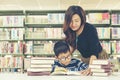 Asian boy reading books for education and go to school with the guidance of him mother in library Royalty Free Stock Photo