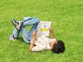 Asian boy reading on lawn Royalty Free Stock Photo