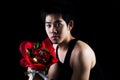 Asian boy with red bouquet in dark background Royalty Free Stock Photo