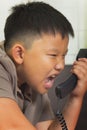 Asian boy scold at the telephone