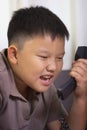 Asian boy scold at the telephone