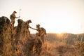 Asian boy scout teams pull their hands up a rocky cliff during a long journey. Unity and teamwork building concept