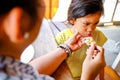 Asian Boy Showing Cranky Facial Expression while Being Feed Lunch Meals by His Mother in A Restaurant