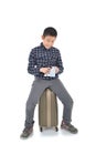 Asian boy sitting on lugguage and holding map Royalty Free Stock Photo