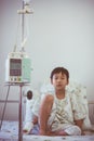 Asian boy sitting on sickbed with infusion pump intravenous IV d