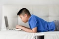 Asian boy sitting on sofa and using laptop Royalty Free Stock Photo