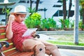 An Asian boy sat on a wooden chair holding a tablet. Royalty Free Stock Photo