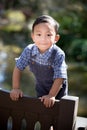 Asian boy smiling and looking straight into camera while outdoors Royalty Free Stock Photo