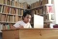 Asian boy student learning studying online with laptop computer in library, school from home Royalty Free Stock Photo