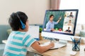 Asian boy student video conference e-learning with teacher and classmates on computer in living room at home. Homeschooling and Royalty Free Stock Photo