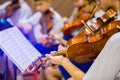 Asian boy students playing violin with music notation in the group. Violin player. Violinist hands playing violin orchestra