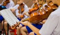 Asian boy students playing violin with music notation in the group. Violin player. Violinist hands playing violin orchestra