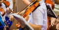 Asian boy students playing violin with music notation in the group. Violin player. Violinist hands playing violin orchestra