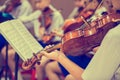 Asian boy students playing violin with music notation in the group. Violin player. Violinist hands playing violin orchestra