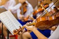 Asian boy students playing violin with music notation in the group. Violin player. Violinist hands playing violin orchestra