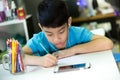 Asian boy using cellphone and painting on a white paper Royalty Free Stock Photo