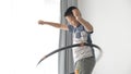 Asian boy using a hula hoop near window at home
