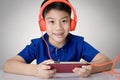 Asian boy ware headphone and playing the cell phone Royalty Free Stock Photo