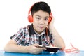 Asian boy ware headphone and playing the cell phone Royalty Free Stock Photo