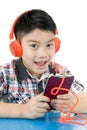 Asian boy ware headphone and playing the cell phone Royalty Free Stock Photo