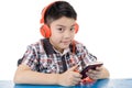 Asian boy ware headphone and playing the cell phone Royalty Free Stock Photo