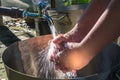 Asian boy washing hands on metal sink Royalty Free Stock Photo