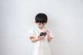 Asian boy Wear traditional Thai clothing play with mobile phone on a white background Royalty Free Stock Photo