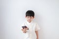 Asian boy Wear traditional Thai clothing play with mobile phone on a white background Royalty Free Stock Photo