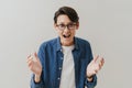 Asian boy wearing eyeglasses screaming and gesturing at camera Royalty Free Stock Photo