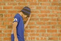 Asian boy wearing a hat Wear street clothes, Stress and pressure, background orange brick wall with copy space