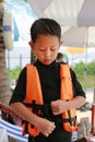 Asian boy wearing life jacket before playing in pool. Kid with life vests. Water safety for children Royalty Free Stock Photo