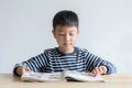 Asian boy who are studying in elementary school reading and doing homework by himself at home Royalty Free Stock Photo