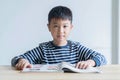 Asian boy who are studying in elementary school reading and doing homework by himself at home Royalty Free Stock Photo