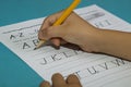 Asian boy writes Letter A with yellow pencil Royalty Free Stock Photo